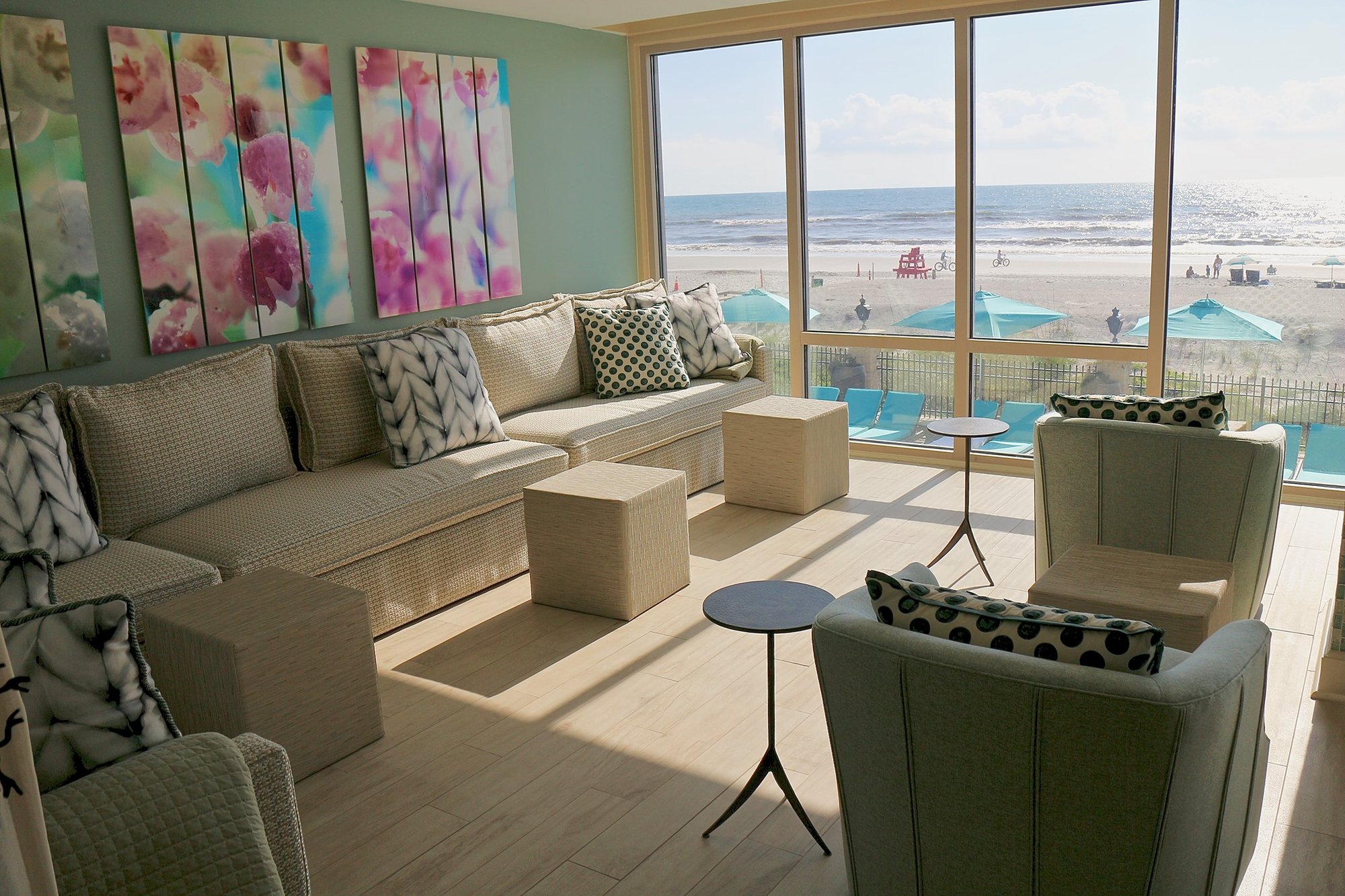aerial-view-of-commercial-space-lounge-with-custom-made-tan-furniture-with-large-window-viewing-a-beach